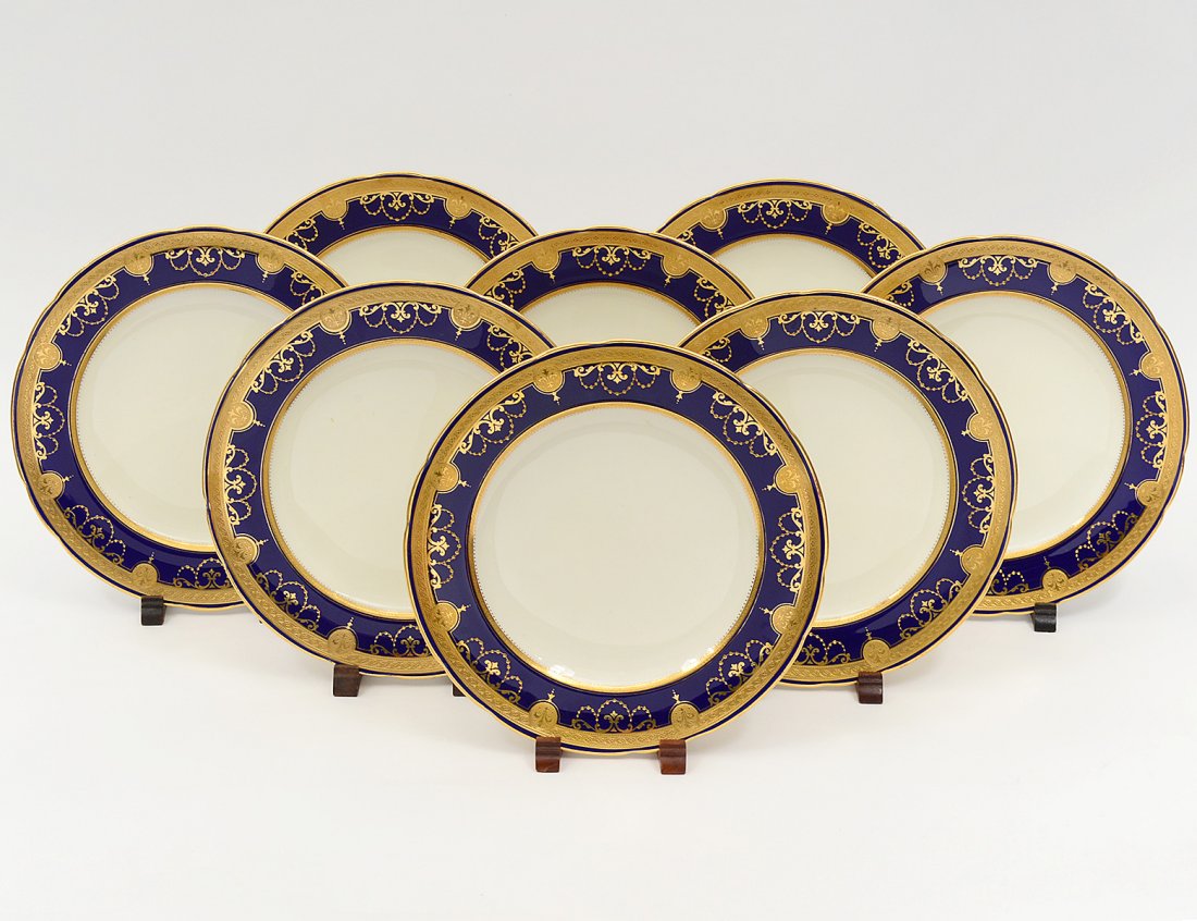 SET OF EIGHT MINTONS PORCELAIN SERVICE PLATES: English. Circa 1920. Each with gilt and cobalt blue shoulder. Diameter 9 3/4". (400/500) Retailed by Tiffany & Co., NY