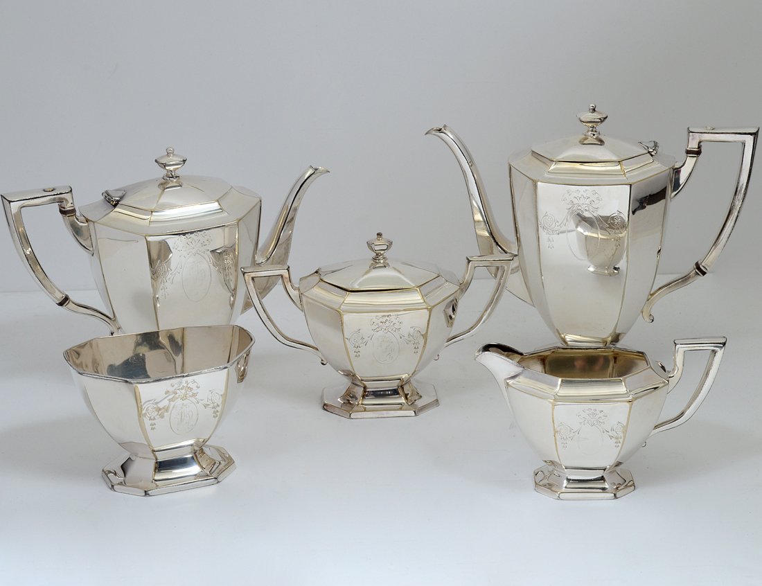 FIVE PIECE SILVER PLATED TEA AND COFFEE SERVICE: American. Circa 1910. Maker: Homan. Comprising: tea pot, coffee pot, covered sugar bowl, creamer and spooner. (Each with monogram) (300/400)
