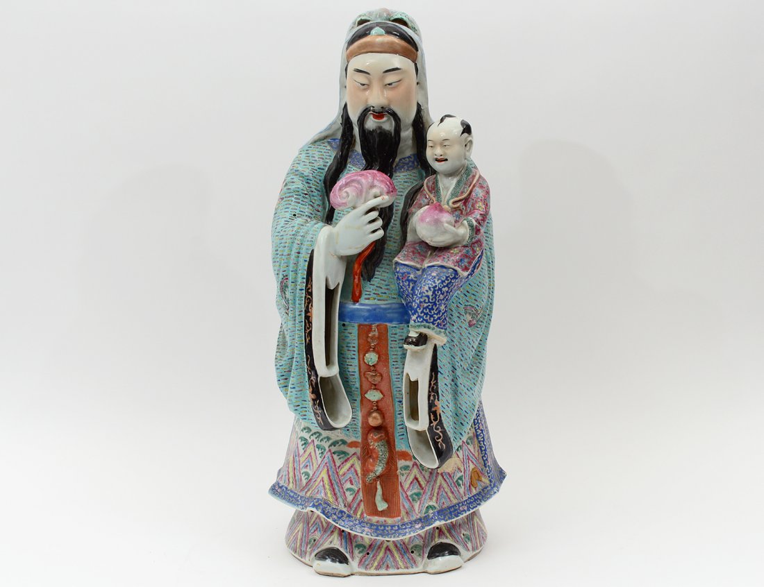 FAMILLE ROSE PORCELAIN GROUP: Chinese. Of a standing court official holding a child and a scepter. Height 24". (300/400)