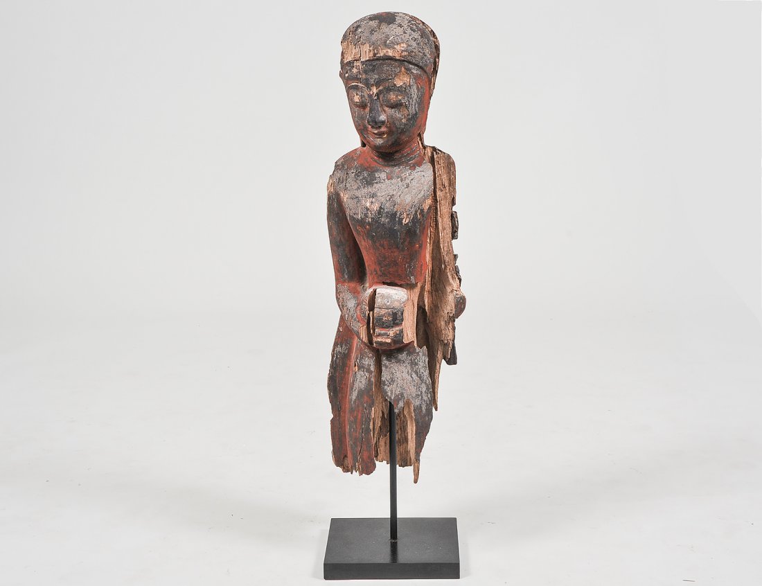 SOUTHEAST ASIAN CARVED WOOD BUDDHA: 19th Century. Raised on an ebonized base. Height 30". (Cond: cracks and losses) (100/150)