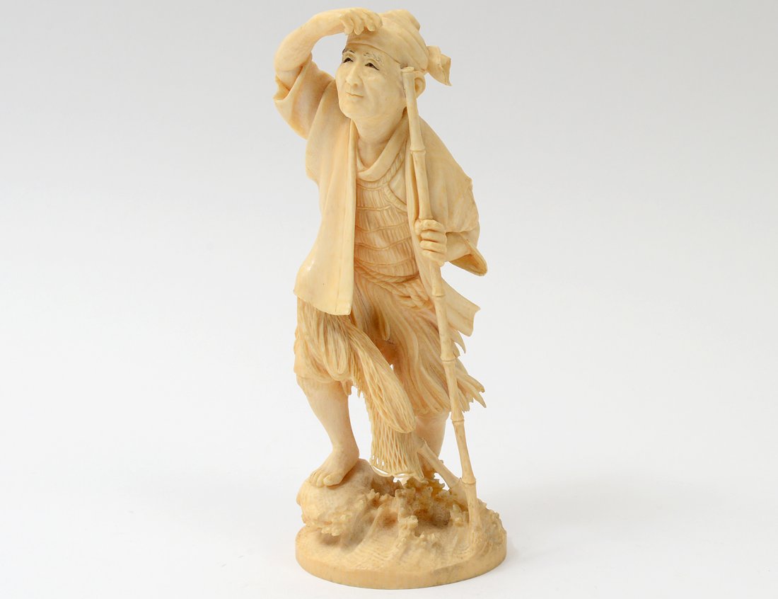 CARVED IVORY FIGURE OF A PEASANT: Japanese. 20th Century. Signed. The man holding a bamboo staff. Height 6 7/8”. (200/250) NOTE: DOMESTIC AND INTERNATIONAL SHIPPING IS NOT AVAILABLE FOR THIS ITEM. This item can only be picked up fro