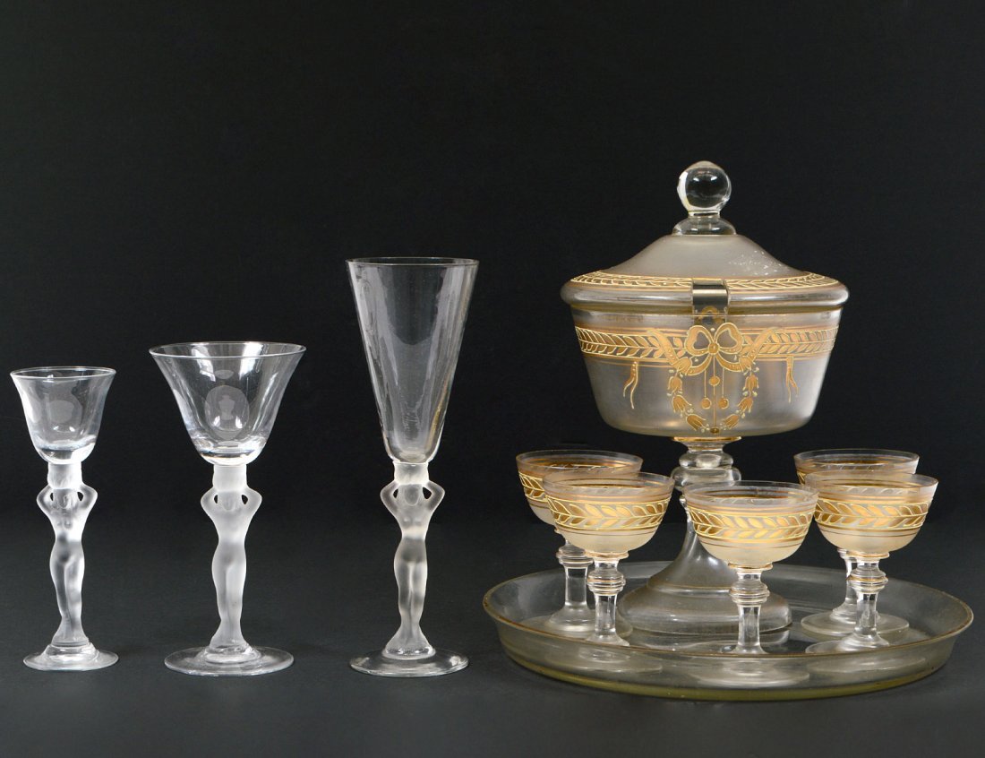 TWENTY-TWO PIECE PARTIAL STEMWARE SET: With frosted female nudes as the stems. Comprising: five cordial glasses, eight wine glasses and nine champagne flutes. Together with a gilt glass cordial set composed of bowl, tray and five glasses.