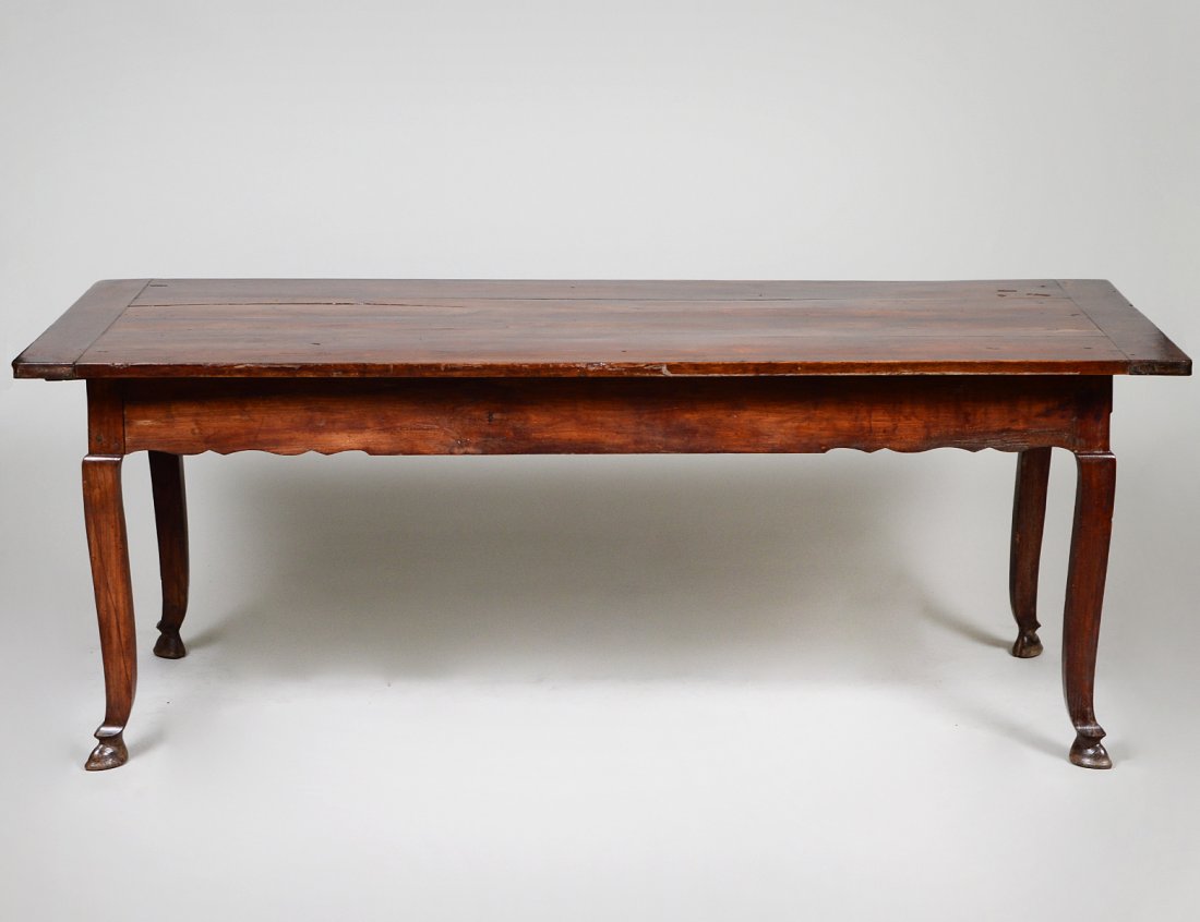 LOUIS PHILIPPE ELMWOOD FARM TABLE: 19th Century. The rectangular overhanging top above a shaped apron fitted with a drawer at one side, on cabriole legs ending in hoof feet. Height 30 “. Width 6’ 5’. Depth 32 ½”. (Cond: some m