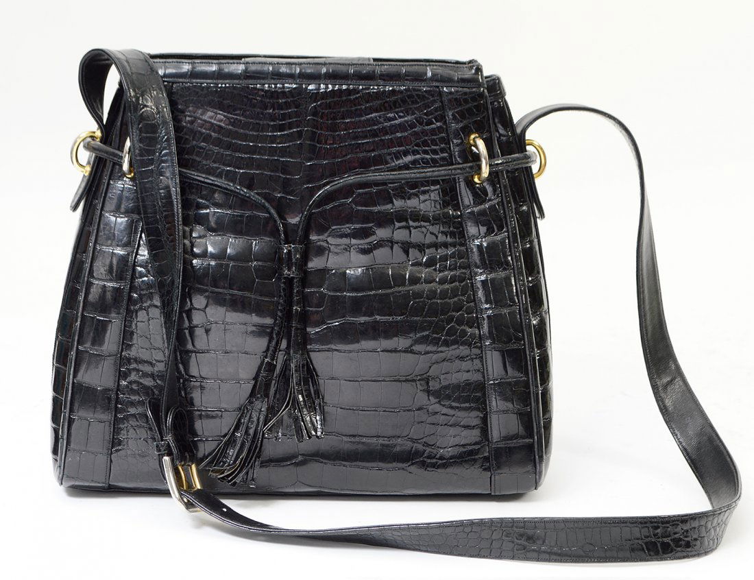 JUDITH LEIBER BLACK ALLIGATOR LADIES BAG: Stamped Judith Leiber, New York. With gold tone hardware and black leather lining. Height 10". Width 12". In the original box with slip cover. Together with Judith Leiber gold tone vanity comb and mir