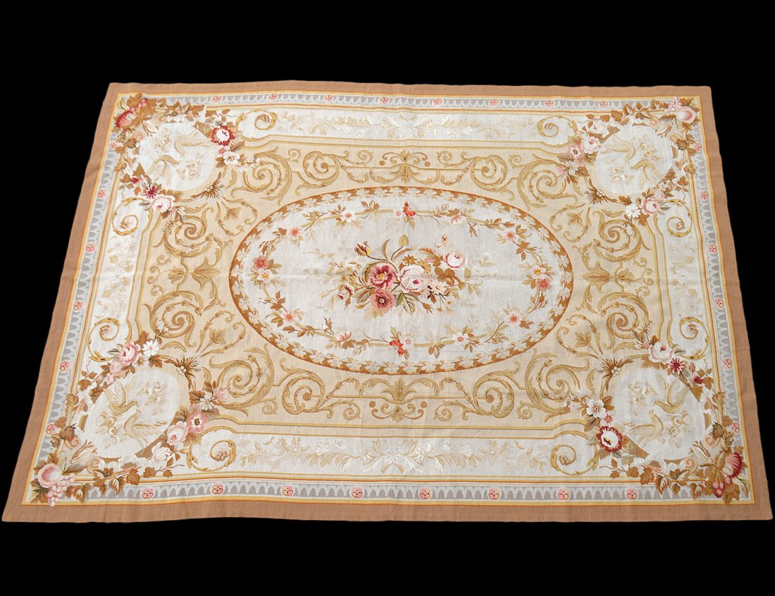 AUBUSSON STYLE CARPET: 20th Century. The design of flowers and scrolls worked in various tones of brown, ochre and cream. Measuring 6’ 11” by 9’ 10”. (150/300)
