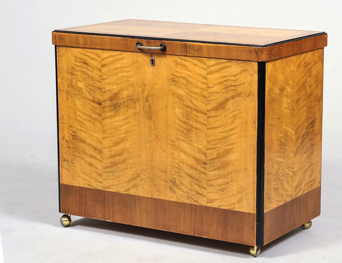 ART DECO MAPLE AND BIRCH BAR CABINET: The hinged top reveals a mechanical platform with bottle wells. Height 23”. Width 27 ½”. Depth 15 ¾”. (50/100)