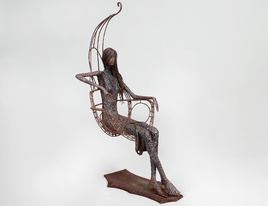 IRON FIGURE OF A WOMAN SEATED IN A CHAIR: Circa 1965. Appears unsigned, the longed hair young lady seated in a hanging chair, the iron fully oxidized. Height 42”. Width 17”. Depth 19”. (Cond: oxidization appears intentional, otherwise g
