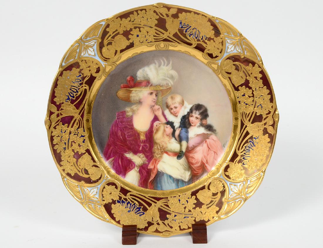 VIENNA PAINTED PORCELAIN CABINET PLATE: Circa 1890. The underside with blue beehive, a stylized gray star and numerous numerals in red. Recessed center signed Wagner, after Joshua Reynolds, “Lady Smith and Her Children”, the border deco