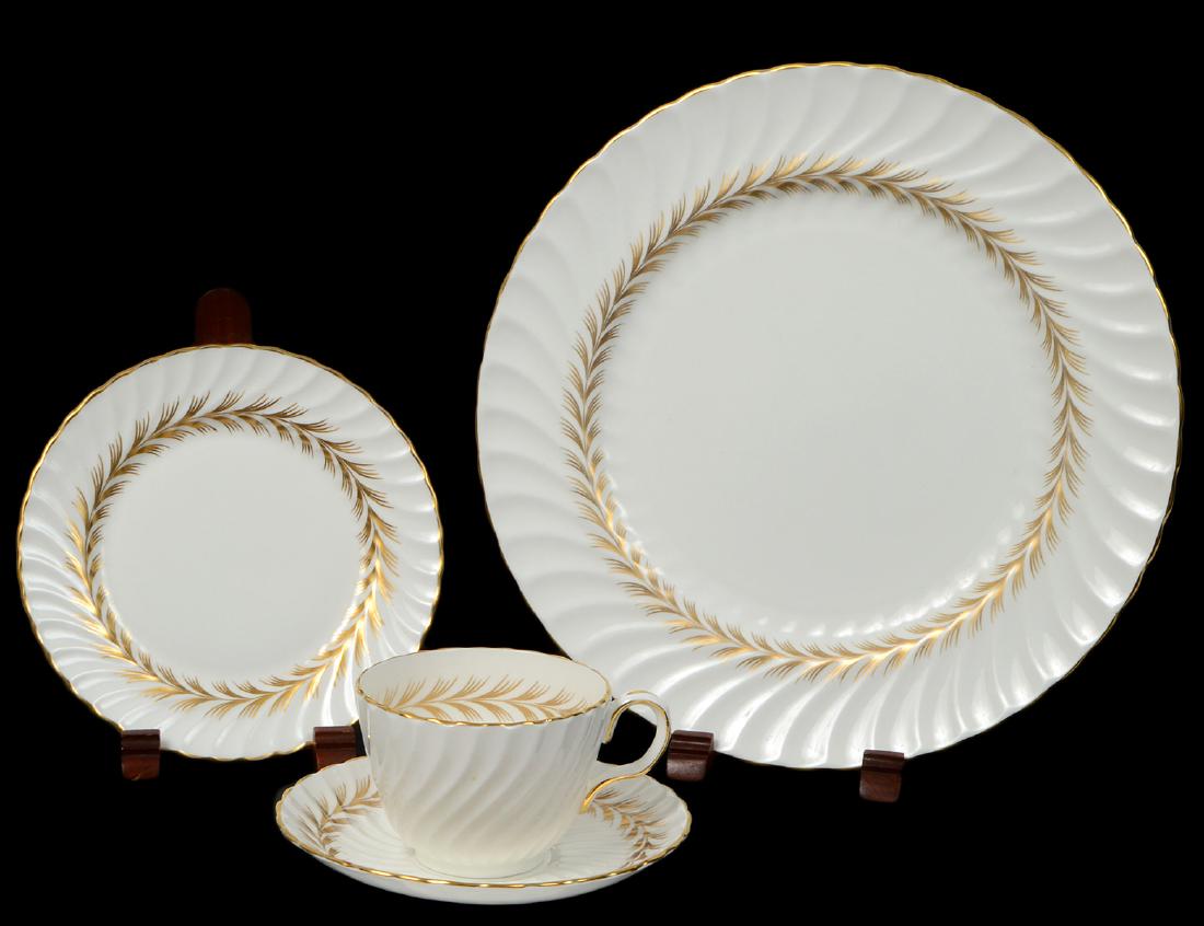 ENGLISH ONE HUNDRED, TWENTY-TWO PIECE PORCELAIN SERVICE: Marked Aynsley Bone China. in the “Arundel” pattern. The cream part dinner service with molded rims and gilt stylized feathered sheaf motifs. Comprising: 18 dinner plates, 19 luncheon plates, 17 b