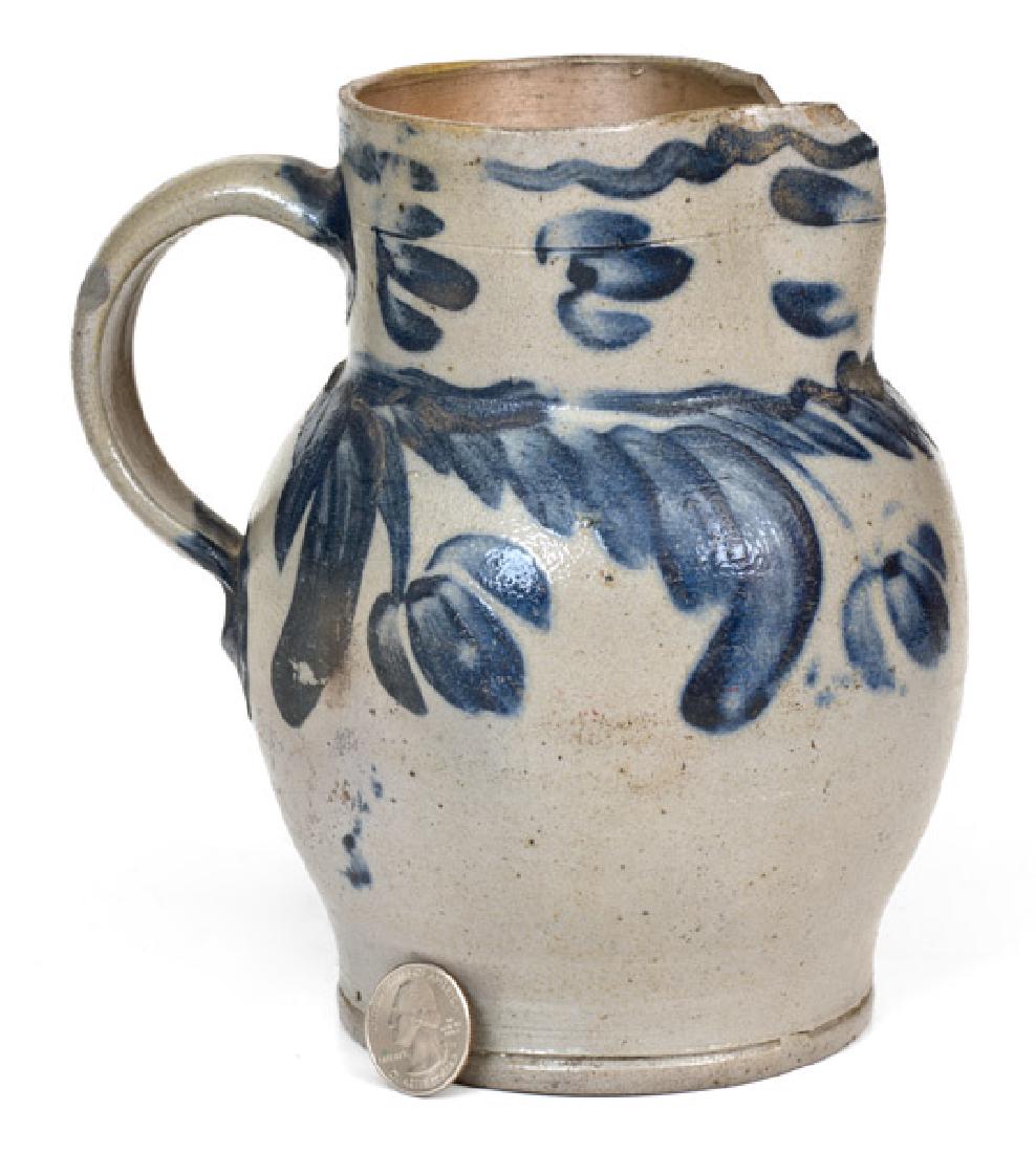 One-Quart Baltimore Stoneware Pitcher with Hanging: Quart-Sized Stoneware Pitcher with Cobalt Floral Decoration, Baltimore, MD origin, circa 1840, ovoid pitcher with footed base and tooled collar, decorated around the midsection with a swag and hanging