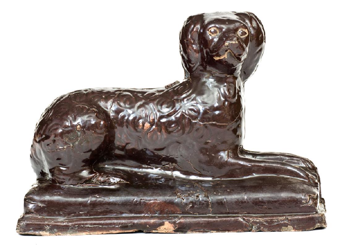 Stoneware Reclining Dog Figure, Jane Lew, WV Origin: Stoneware Figure of a Reclining Spaniel, Jane Lew, WV origin, circa 1875, molded figure of a reclining spaniel on rectangular base, covered in a glossy brown Albany slip glaze. Incised details to eyes