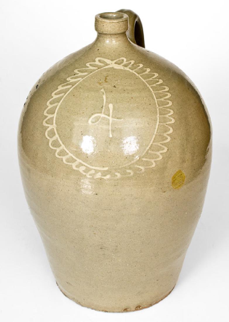 Attrib. Thomas Chandler, Edgefield District, SC: Four-Gallon Stoneware Jug with Kaolin Slip Decoration, attributed to Thomas Chandler, Edgefield, SC, circa 1850, ovoid jug with squared spout, decorated in kaolin slip with a large stylized flower blo
