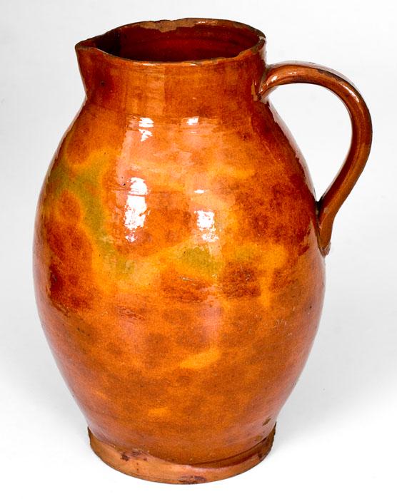 Fine New England Glazed Redware Pitcher: Fine Glazed Redware Pitcher, New England origin, late 18th or early 19th century, thin-walled, ovoid pitcher with footed base and short collar, the surface covered in a heavy lead glaze featuring beau