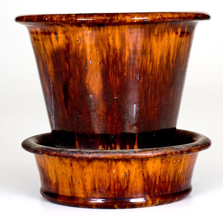 JOHN W BELL / Waynesboro, Pa. Redware Flowerpot: Glazed Redware Flowerpot, Stamped "JOHN W BELL / Waynesboro, Pa.", circa 1880, tapered pot with attached saucer, the surface decorated with streaks of manganese and covered in a clear lead glaze. Unde