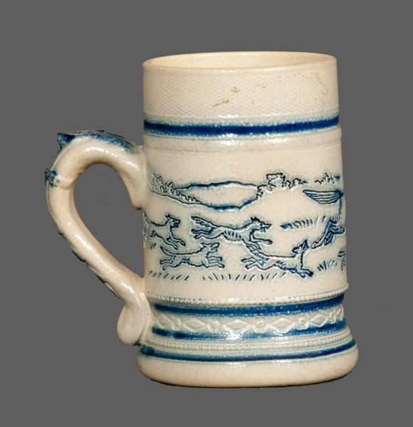 Molded Stoneware Mug with Impressed Decoration: Cobalt-Decorated Stoneware Mug with Impressed Decoration, attributed to the White's Pottery, Utica, NY, late 19th century, molded mug with impressed scene of foxes chasing a man strapped to the back o