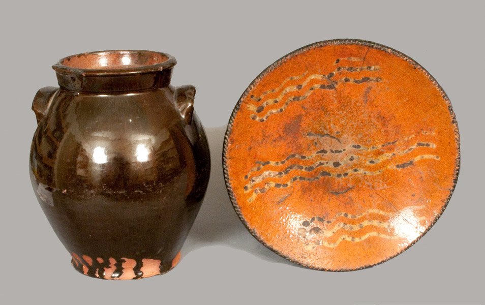Lot of Two: Glazed Redware Jar and Slip-Decorated Redwa: Two Pieces of Glazed Redware, American, 19th century, an ovoid jar with handles, the surface covered in a brownish lead-and-manganese glaze, paired with a slip-decorated redware plate with coggled edg