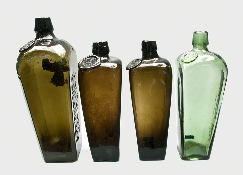 Four Glass Gin Bottles, Dutch, 19th century: Four Glass Gin Bottles, Dutch, 19th century, including a light-green VAN DEN BERGH & CO bottle with bell seal; an olive MEDER with swan seal; a J.H. HENKES with stork seal; and a Van Duken Weiland & C