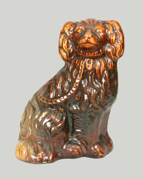 Albany-Slip-Glazed Stoneware Dog Doorstop, Midwestern o: Albany-Slip-Glazed Stoneware Dog Doorstop, Midwestern origin, late 19th century, molded in the form of a seated spaniel with leash, collar, and locket, the surface in a mottled brown glaze. Hand-incis