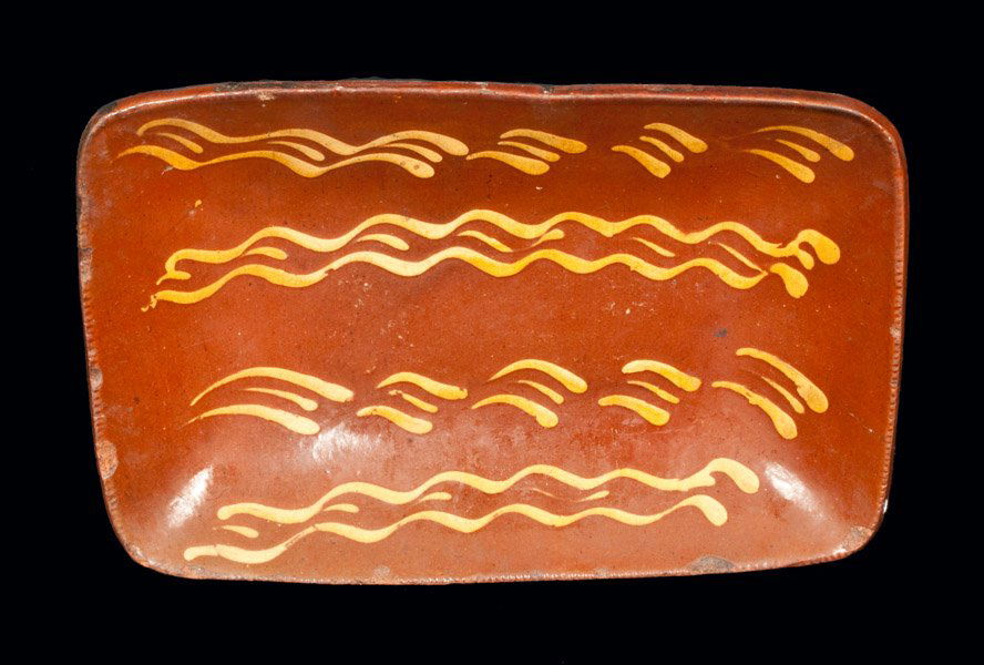 Redware Loaf Dish with Profuse Yellow Slip Decoration,: Fine Redware Loaf Dish with Profuse Slip Decoration, possibly Norwalk, CT, first half 19th century, with coggled edge, the interior with four alternating bands of yellow slip decoration. Clear lead-gl