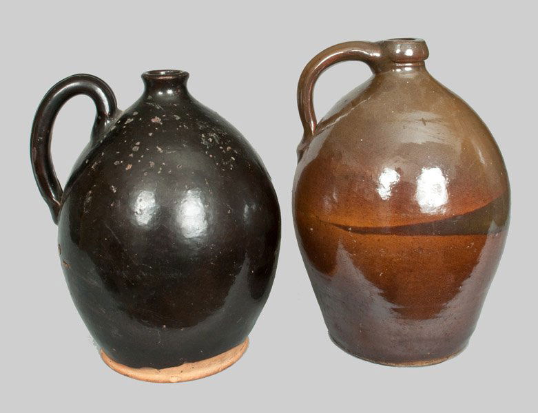 Lot of Two: Manganese-Hlazed Redware Jug and Albany: Two Glazed Pottery Jugs, American, 19th century, an ovoid redware jug with heavily-ribbed handle and blackish lead-and-manganese-glazed surface, first half 19th century; paired with a one-gallon ovoid