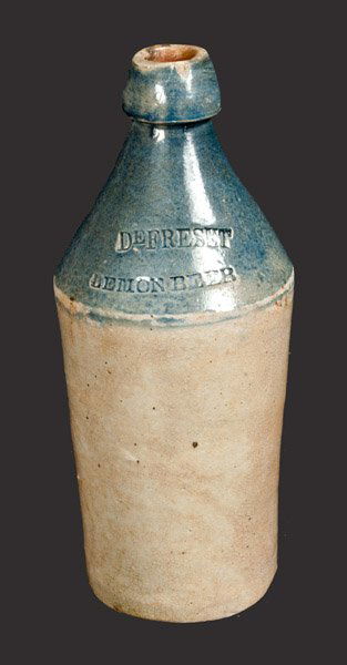 Stoneware Bottle with Bright Blue-Dipped Top Impressed: Cobalt-Dipped Stoneware Bottle, Stamped "DEFRESET LEMON BEER," Northeastern U.S. origin, third quarter 19th century, cylindrical bottle with tapered spout, the bottle dipped to the shoulder in bright