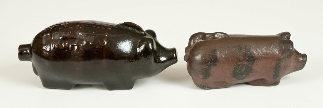 Lot of Two: Stoneware Pig Flasks incl. Razorback Hog: Two Stoneware Pig Bottles, Midwestern origin, late 19th century or early 20th century, a molded razorback hog bottle with applied spine of hair, Albany slip-glazed surface, and embossed inscription "D