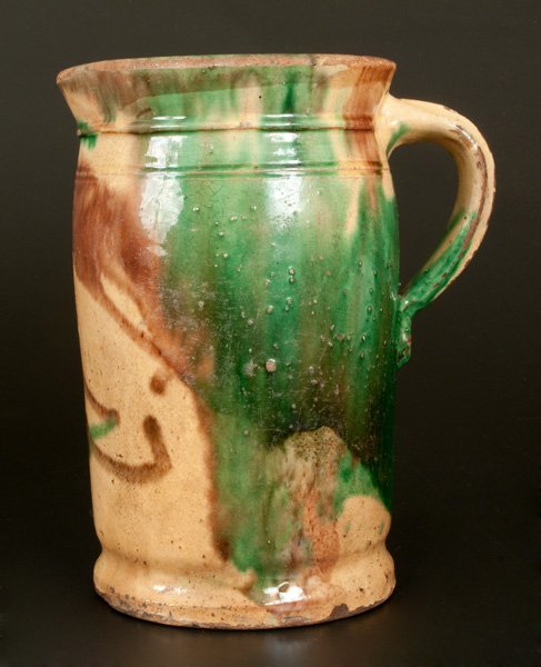 Shenandoah Valley Multi-Glazed Redware Tankard Pitcher: Multi-Glazed Redware Tankard Pitcher, attributed to S. Bell & Son or J. Eberly & Co., Strasburg, VA, late 19th century, cylindrical form with footed base, tooled shoulder, and flared rim, the surface