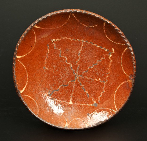 Small Slip-Decorated Redware Plate, Possibly: Slip-Decorated Redware Plate, possibly New England, early to mid 19th century, with coggled edge, decorated with an unusual yellow slip square with segmented interior, bordered with draped yellow slip
