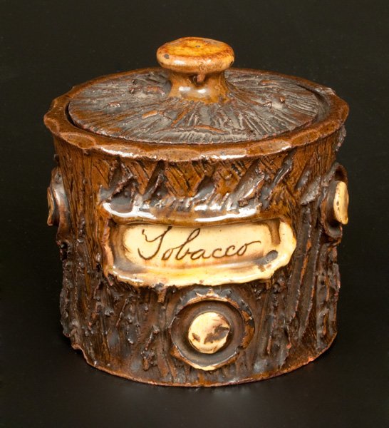 Redware Lidded Rusticware Tobacco Jar: Glazed Rustic Redware Tobacco Jar, English, late 19th century, wheel-thrown, lidded jar in the form of a tree stump with applied knots and incised bark. Decorated with cream-colored slip and incised "