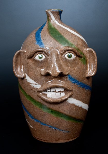 Joe Reinhardt Stoneware Swirl Face Jug: Swirl-Glazed Stoneware Face Jug, Signed and Dated "Joe Reinhardt / Vale, NC / 2-2-2002," North Carolina origin, ovoid jug with applied face including open mouth and teeth, the surface covered in a swi
