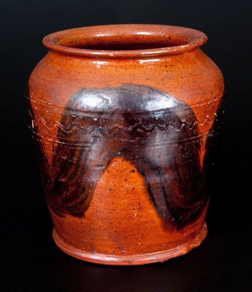 Redware Jar w/ Manganese Decoration and Incised Lines,: Manganese-Decorated Redware Jar, Pennsylvania origin, 19th century, squat-shaped jar with footed base, rounded shoulder, and flared rim, the shoulder decorated with an incised wavy line design. Surfac