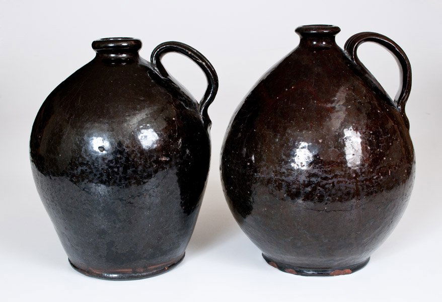 Attrib. Thorn Pottery, Chesterfield, NJ Ovoid Redware: Two Glazed Redware Jugs, attributed to the Thorn Pottery, Chesterfield, Burlington County, NJ, early 19th century, two ovoid jugs with footed bases, rounded spouts, and heavily-ribbed handles, their s