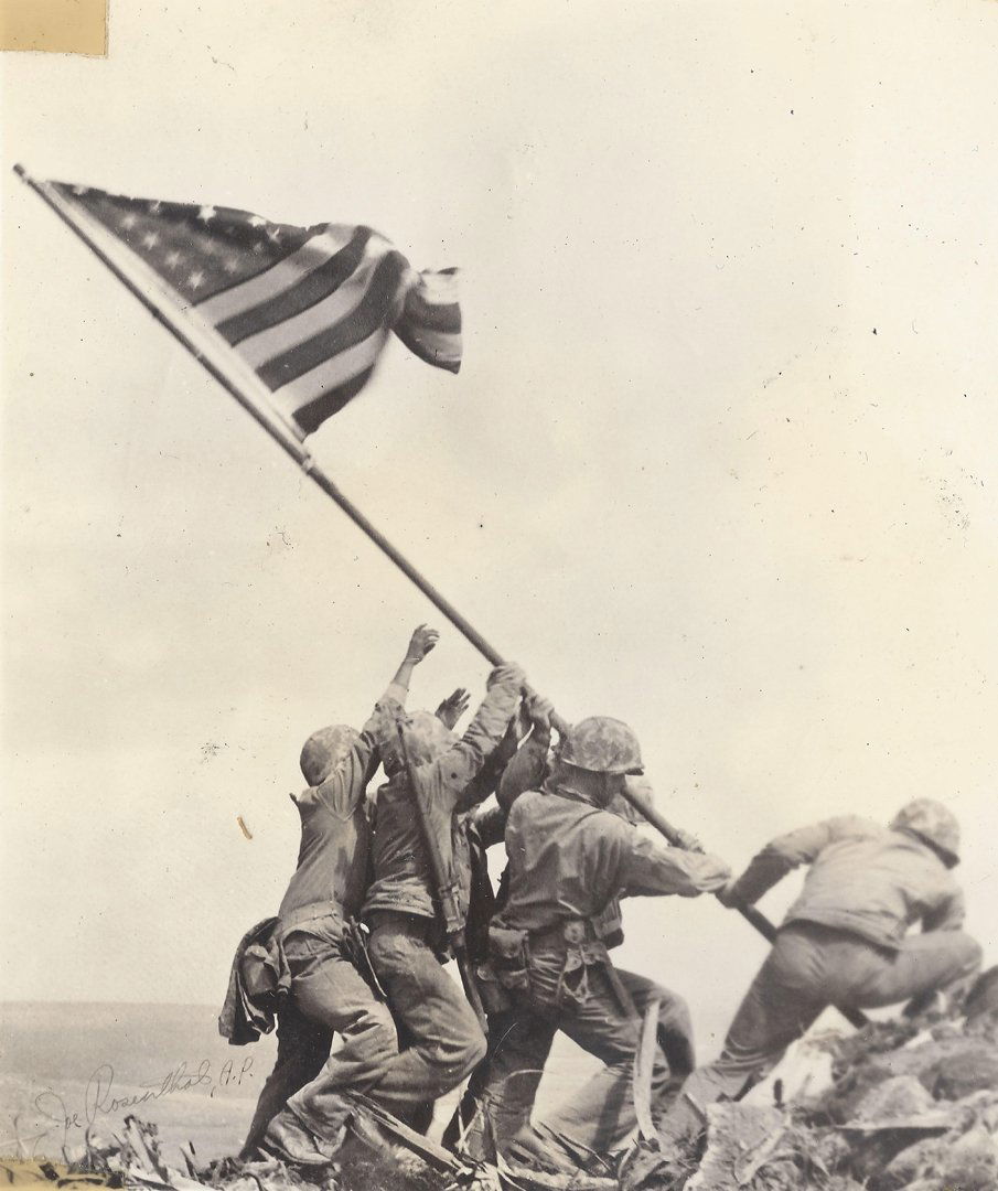 Joe Rosenthal & Pacific Theater Photographs, 1945.: Thirteen (13) photographs of the US Military in the Pacific Theater during World War II. One (1) being an image of the flag raising at Iwo Jima with Joe Rosenthal's name in the the bottom-left corner