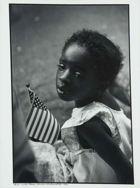 Earlie Hudnall, Jr.(American, b. 1946) Girl: Earlie Hudnall, Jr.(American, b. 1946) Girl With Flag, 1991; Gelatin silver print; Signed, dated and titled; 20" x 16" (sheet)