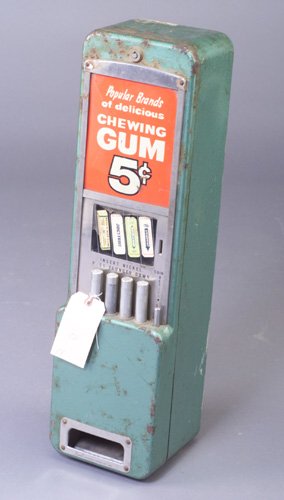 "Gum 5 Cents", wall-mounted dispenser in: "Gum 5 Cents", wall-mounted dispenser in green galvanized metal with Wrigley's, Juicy Fruit, etc. signage. 30"