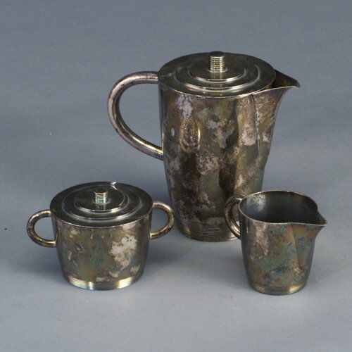 Three-piece LURELLE GUILD silver-plated: Three-piece LURELLE GUILD silver-plated Art Deco coffee service by WP with pot, covered sugar bowl and creamer, with ribbed bases and finials. Handle of coffee pot re-soldered, a few small dents. Stam