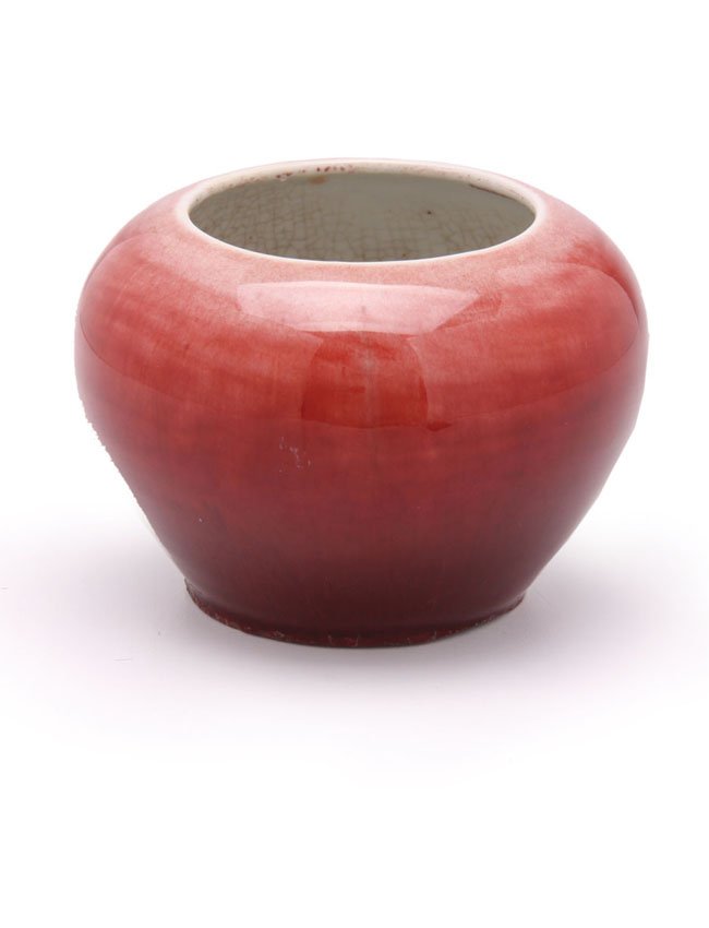 A Chinese porcelain brush pot: With ox blood glaze which has overrun foot. Inside and underside with crackle glaze. H. 10cm.