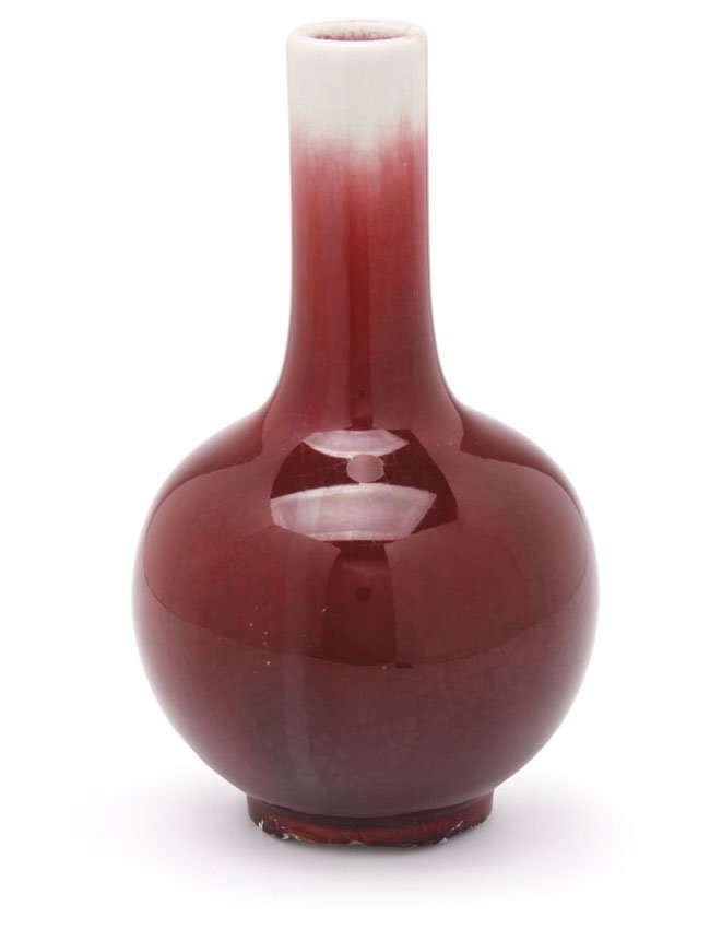 A Chinese porcelain vase: decorated in ox blood red glaze. The underside and rim with crackle white glaze. Glaze has overrun foot. H. 24cm.