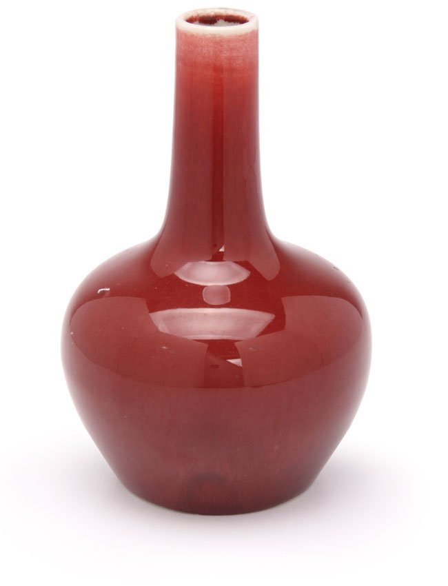 A Chinese porcelain bottle vase: Covered in an ox blood glaze. The underside with white crackle glaze. H. 18cm.