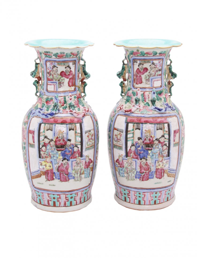 Large Pair of Canton Famille Rose Baluster Vases: Decorated with panels of figures below a border of high relief lizards and fu dogs. Minor expected signs of wear. H. 46cm.