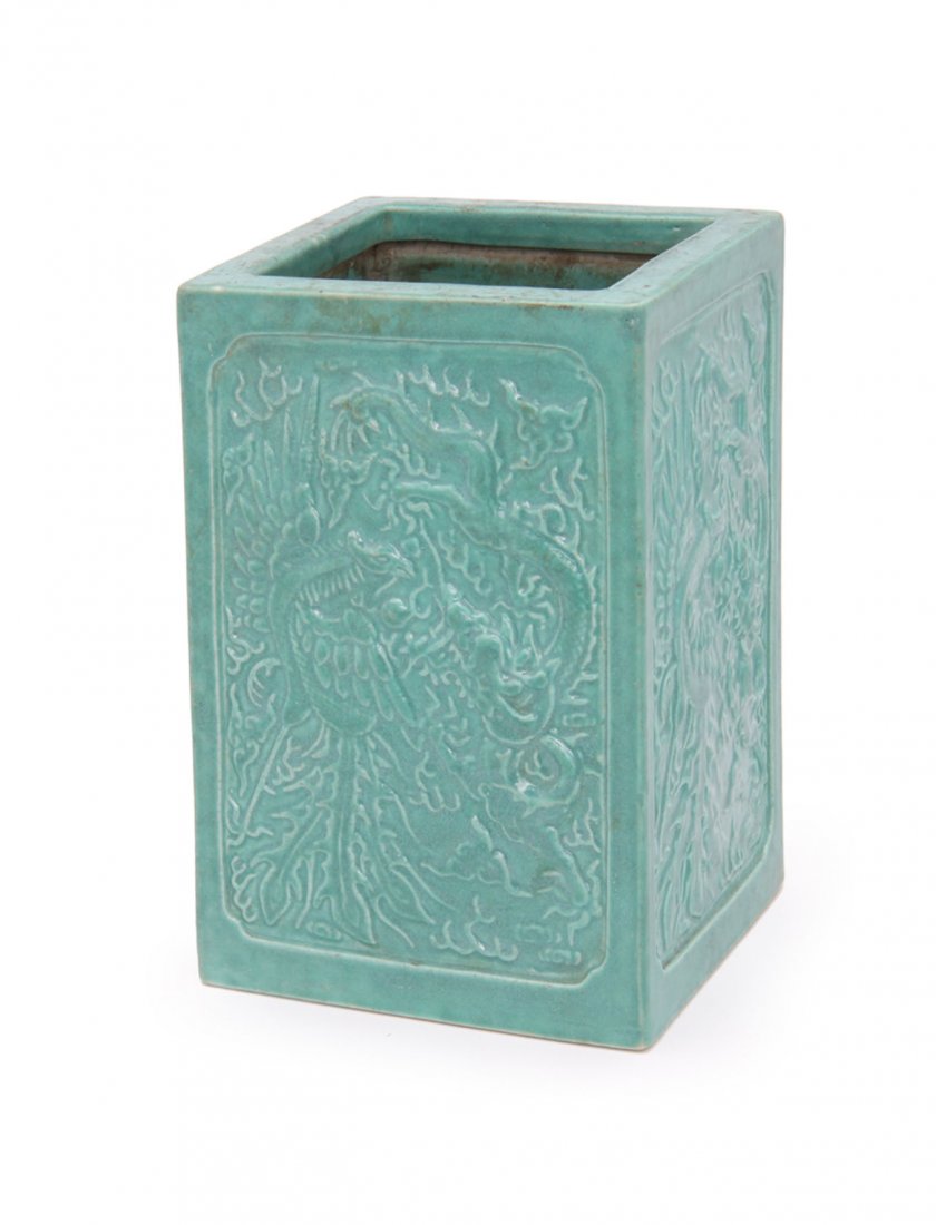 A Chinese Porcelain Brush Pot: Decorated in relief with dragons and phoenix in a turquoise/green glaze. Incised Qian Long mark. H. 17cm.