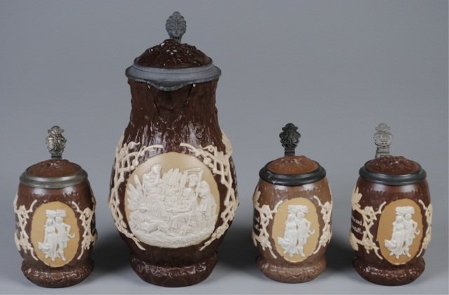 Four Mettlach Steins: 2.3L, 1028, relief, inlaid lid, background like tree trunk, harvest scene; three .5L, 1028, relief, inlaid lid, background like tree trunk, man with woman, carrying hay (one with lid rim dent) Provena