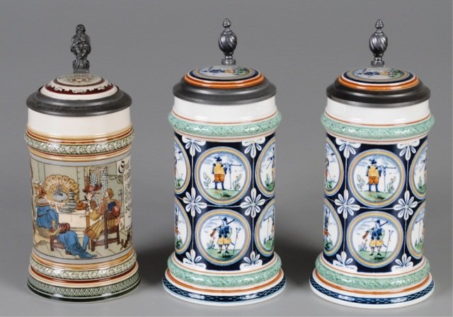 Three Mettlach Steins: .5L, 2005, etched, inlaid lid, four people having dinner, signed H.D.; two .5L, PUG, inlaid lid, musketeers with weapons, mkd "Alt Mettlach" Provenance: Dennis Galloway Estate, Etowah, NC
