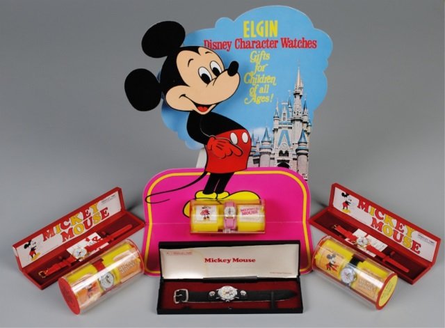 Six Disney Wristwatches with Elgin Display: wristwatches by Bradley Times (Elgin Watch Co.): five Mickey Mouse (3 w/red bands, 2 w/black bands), Minnie Mouse w/pink band; all w/original cases; Elgin Disney Character Watches cardboard stand-up d