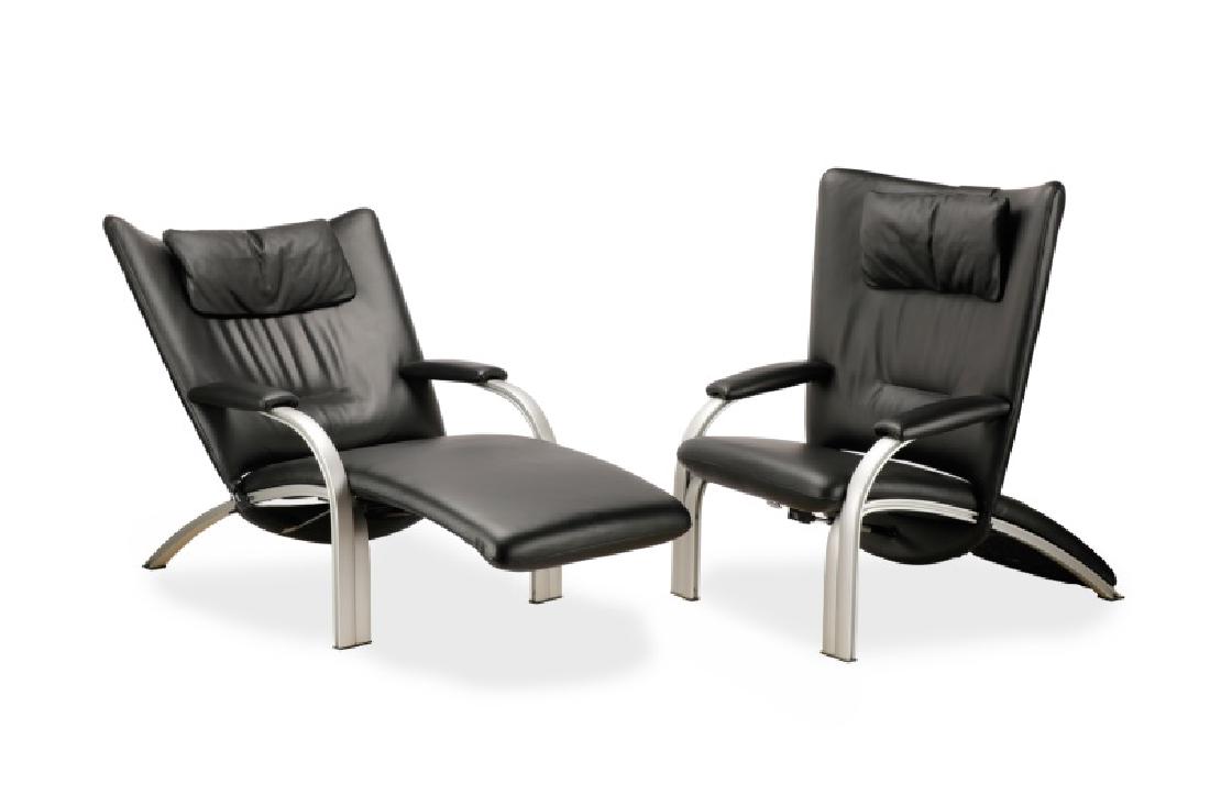 Pair, WK Wohnen Reclining Black Theatre Chairs: WK Wohnen (German, founded 1912), circa 2000s. A pair of black leather and chromed metal reclining theatre chairs, each having a scooped back and a headrest. Metal labels to side. Approximate height 4