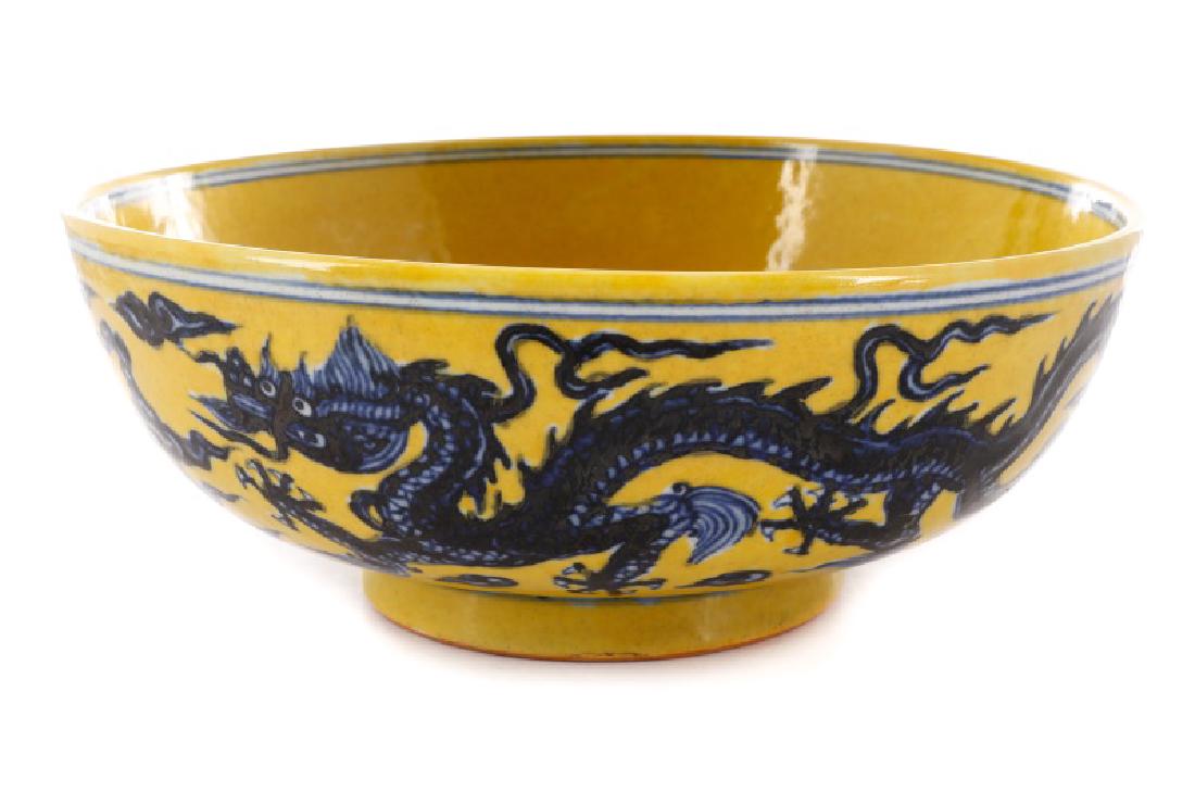 Chinese Famille Jaune Dragon Bowl, Xuande Mark: Chinese, Ming Dynasty Xuande Period mark (1426-1435), likely later. A famille jaune enameled porcelain bowl raised on a ring foot, with cobalt blue underglaze dragons to interior central medallion and