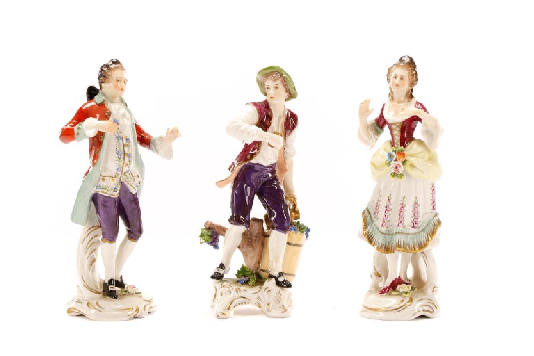 Group of 3 Porcelain Figurines, Rudolf Kammer: Rudolf Kammer (Germany (Volkstedt), founded 1953), circa 1961-1972. A group of three vintage hand painted porcelain figurines comprising a Rococo style man and woman along with a figurine of a wine ma