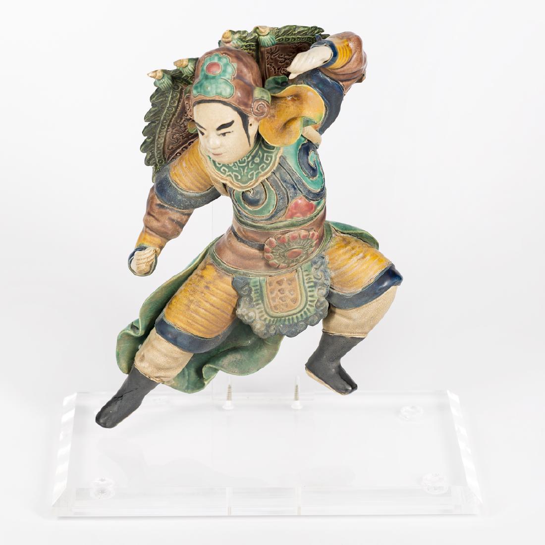 Chinese Terracotta Figural Roof Tile on Stand: Chinese A glazed terracotta warrior roof tile on acrylic stand Unmarked Approx. 9.5" (warrior); h. 11.75", w. 10" (on stand)