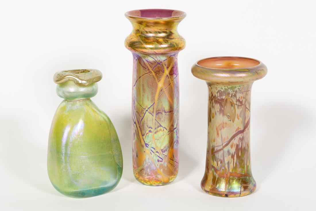 Kim Newcomb, Three Art Glass Iridescent Vases: Kim Newcomb (American, 20th century). A group of three hand crafted iridescent art glass vases. Signed and dated on underside. Approx. h. 9.5" (tallest); h. 6.25" (smallest)
