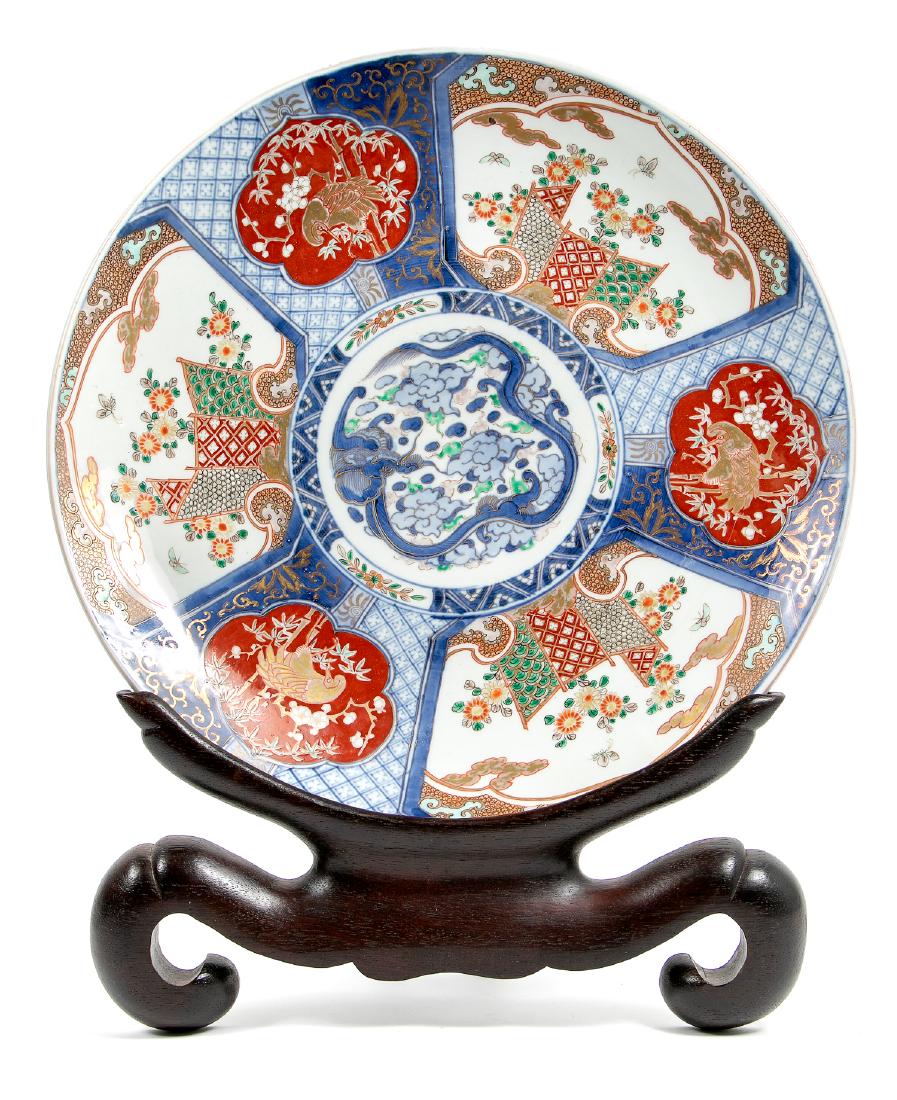 Large Japanese Charger w/ Wooden Stand: Good Japanese Meiji period charger with wood stand, the center section slightly indented. Colorfully decorated with a dragon and birds, with gilding throughout. Approx. diameter 18". Provenance: From